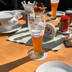 Glasses of Augustiner wheat beer on a sunlit table at Wintergarten in Munich
